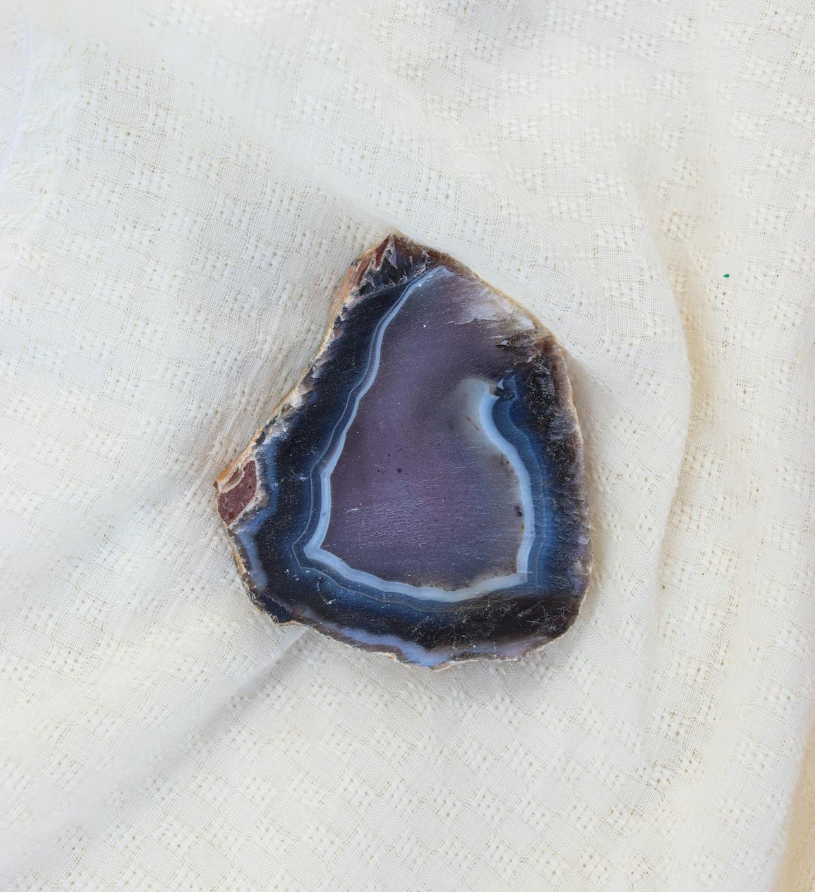 close up of agate geode slice on white fabric