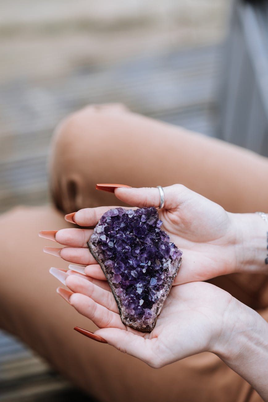 crop woman with amethyst in hands